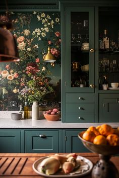 a kitchen with green cabinets and floral wallpaper