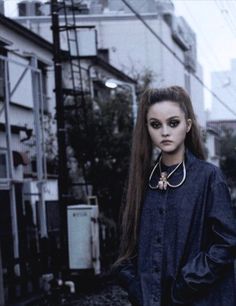 a woman with long hair standing in the street