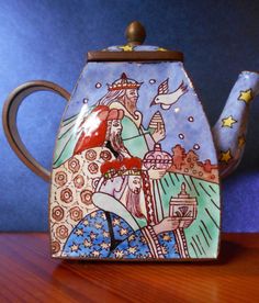 a ceramic teapot with a painting on it