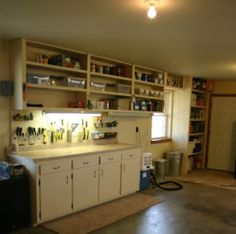 a small dog standing in the middle of a room with lots of shelves and cabinets