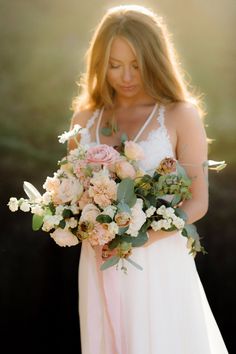 a woman holding a bouquet of flowers in her hands