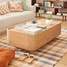 a living room with a couch, coffee table and bookshelf in the background