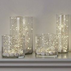 three glass vases with lights in them on a shelf