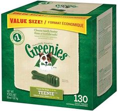 a box of greenies dog treats with a brown and white dog in it's mouth