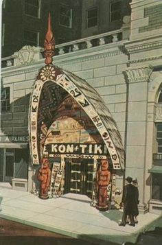 an old photo of a building in the middle of winter with people walking around it