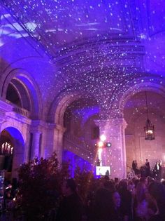 a large room filled with lots of people under stars on the ceiling and lights in the ceiling