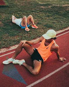 a man sitting on the side of a running track