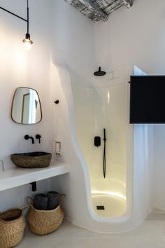 a bathroom with a large shower, sink and mirror on the wall next to two wicker baskets