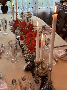 a dining room table set with candles and flowers