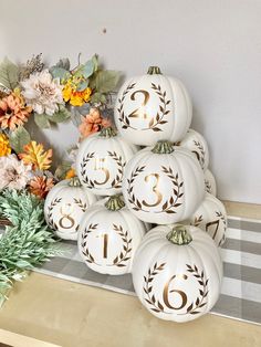 white pumpkins with gold numbers on them and flowers