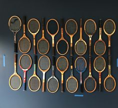 many tennis rackets are lined up on the wall next to each other in different colors