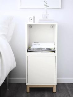 a small white cabinet with books on top