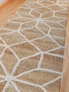 a beige and white rug on the floor in front of a door with wooden floors