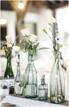 three vases with flowers in them sitting on a table