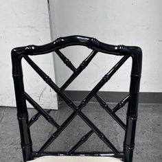 a chair made out of black bamboo with a white seat pad on the bottom and back