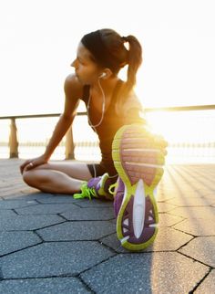 a woman sitting on the ground with her headphones in her ears