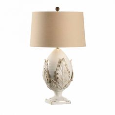 a white lamp with a beige shade on it