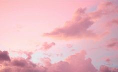 an airplane is flying in the sky at sunset or dawn with clouds and pink hues