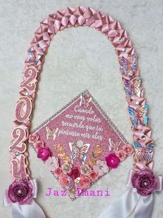 a pink graduation cap decorated with flowers and ribbons