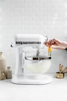 a woman is mixing ingredients in a mixer