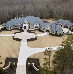 an aerial view of a large home surrounded by trees