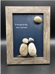 two rocks sitting next to each other in a wooden frame