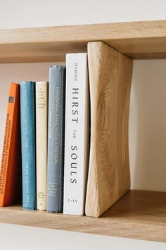 a wooden book shelf with books on it and two different colored books in the middle