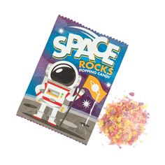 a bag of space rocks next to a small pile of colored sprinkles