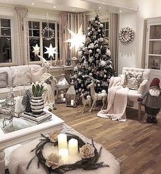 a living room filled with lots of furniture and a christmas tree in the middle of it