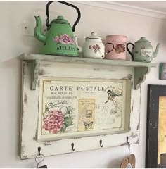 there is a tea pot on top of a shelf above a sign that says cartte postale