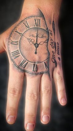 a person's hand with a clock tattoo on it