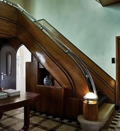 a room with a desk, chair and stairs leading to the second floor bedroom area