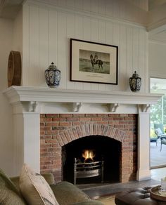 a living room filled with furniture and a fire place under a painting on the wall