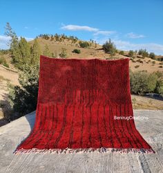 a red blanket sitting on top of a cement slab