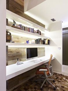 a desk with a computer on top of it in front of a bookshelf