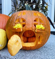 a pumpkin with its mouth open next to other pumpkins