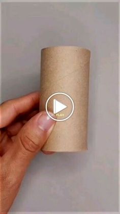 a hand holding a roll of toilet paper with the play button on it and an arrow in the middle