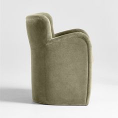 an upholstered chair with a curved back and foot rest, in light green velvet