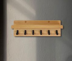 a wooden coat rack with six black knobs