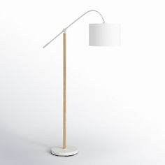 a white floor lamp with a wooden base and a white shade on the light bulb