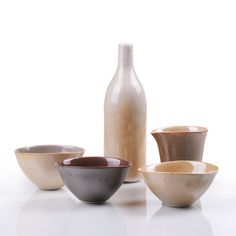 a white table topped with bowls and a bottle