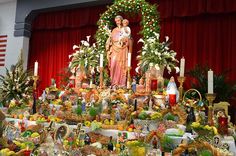 a table filled with fruits and vegetables next to a statue