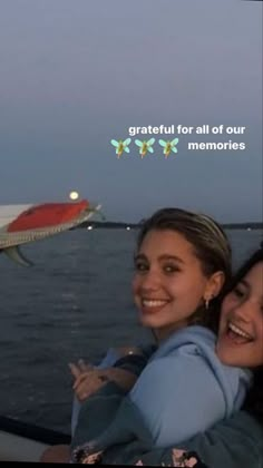 two girls are smiling while riding in a boat