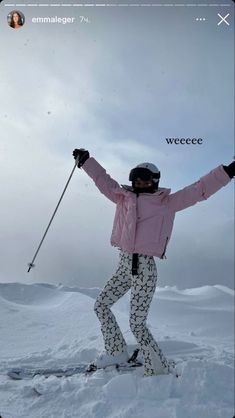 a person on skis with their arms in the air