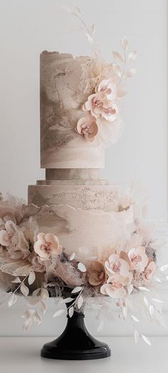 a three tiered cake with flowers on top