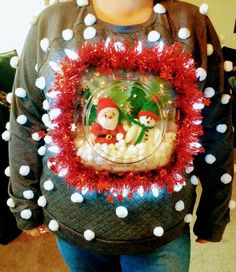 a woman is wearing a christmas sweater with decorations on it