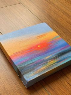 a painting on a wood floor with the sun setting