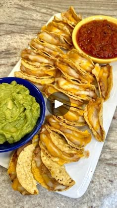 a platter with chips, guacamole and salsa