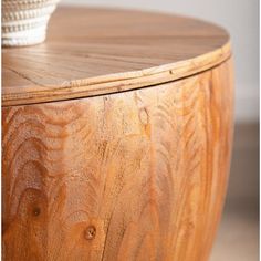 a wooden table with a white bowl on it's top and wood grain in the bottom