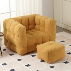 a yellow chair and foot stool in a room with white tiles on the floor, next to a window